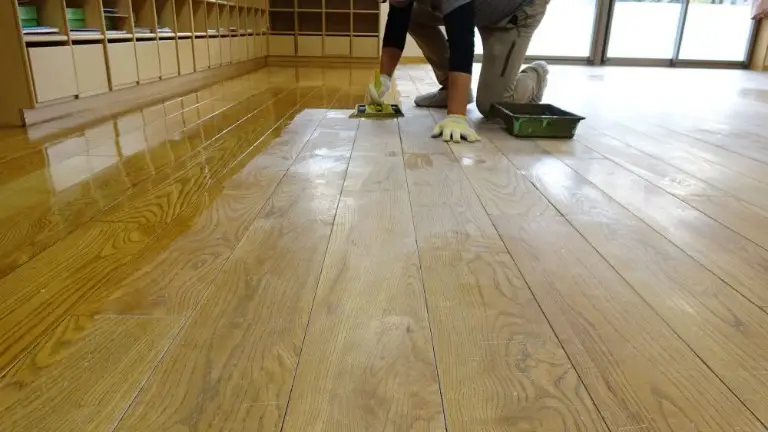 保育室の木の床に滑り止めオイルを塗っているところ