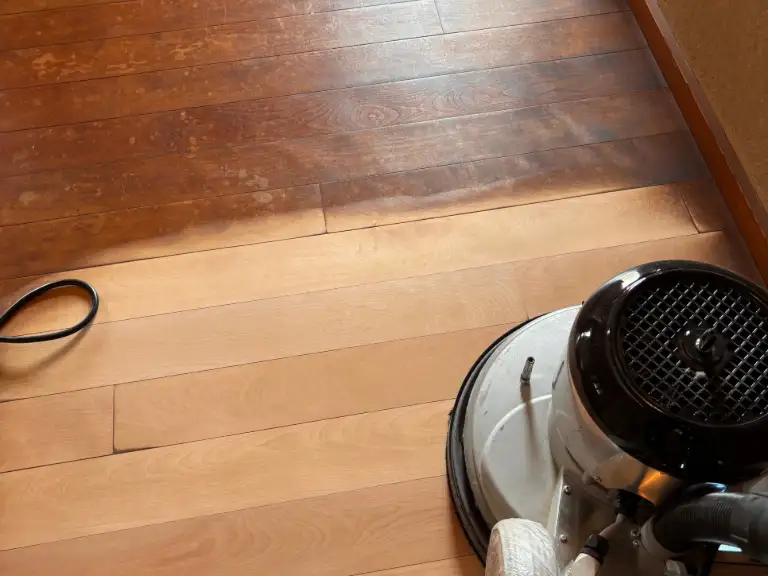住宅の無垢フローリングを研磨機で研磨しているところ（手前が研磨後、奥が研磨前）